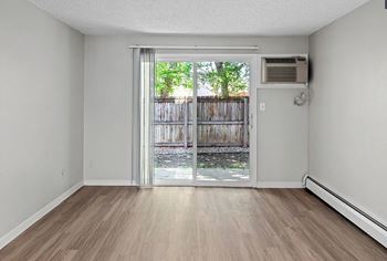 A room with a sliding glass door leading to a backyard.